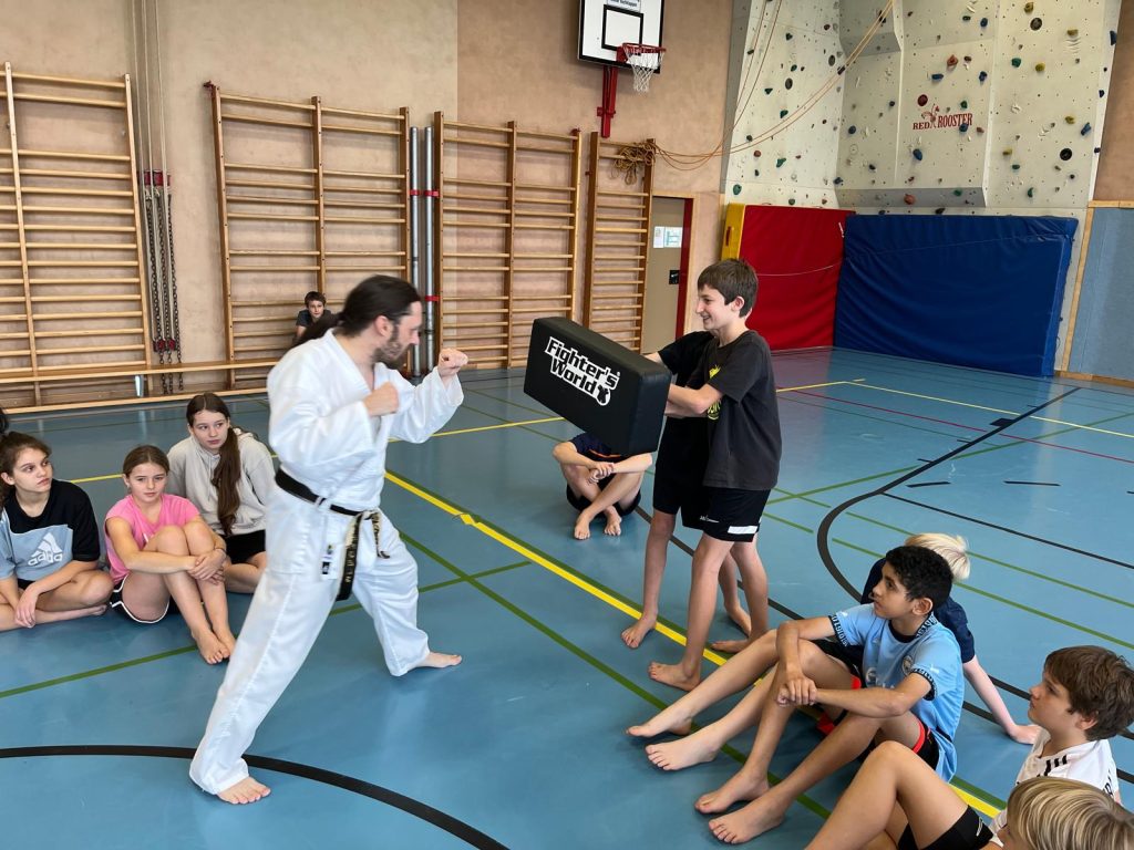 Schüler halten Schlagpolster für Trainer