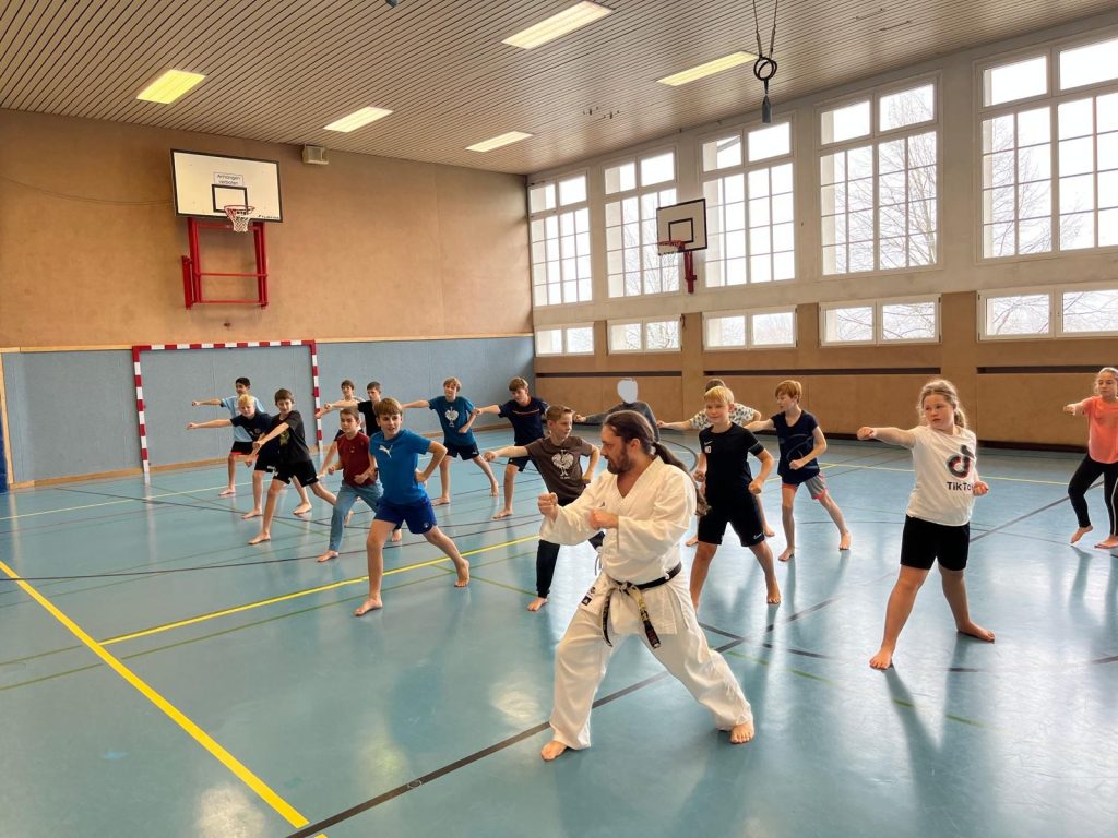 Schüler machen Fauststoß, und Trainer davor