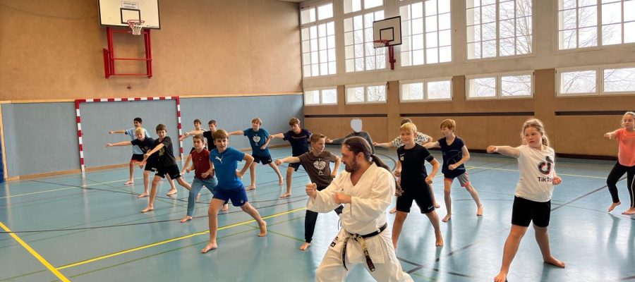 Schüler machen Fauststoß, und Trainer davor